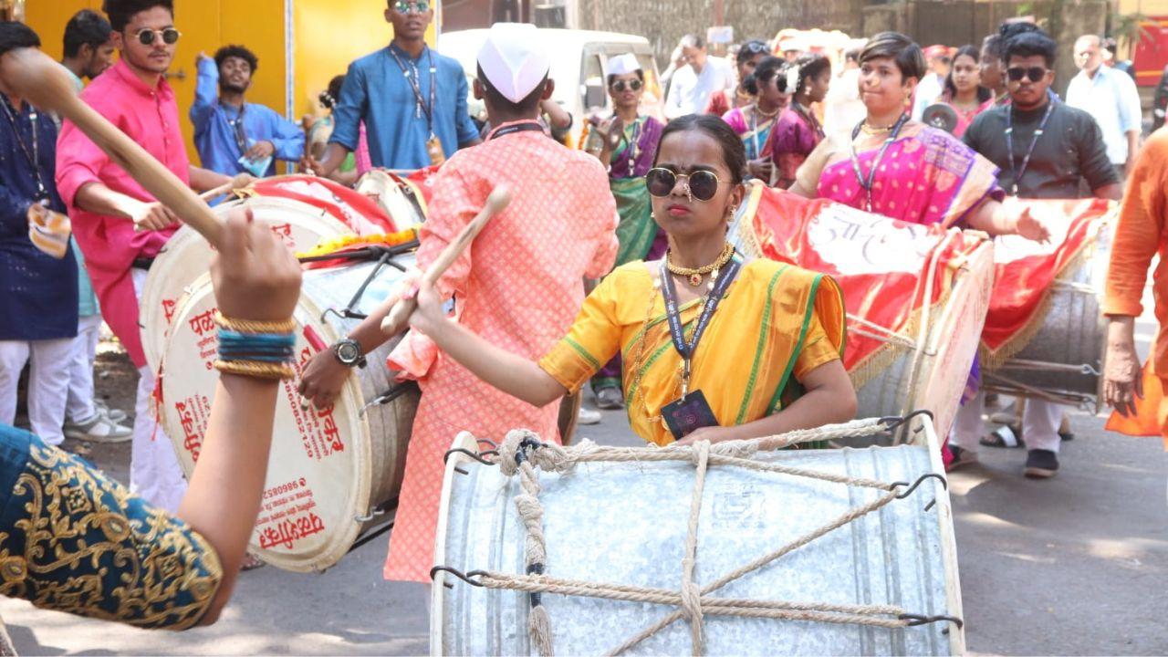 A girl adds energy to the celebration by playing the dhol sporting a yellow nauvari saree and pairing it with black shades at a shobha rally in Goregaon. (Mid-day Photo/Anurag Ahire) 